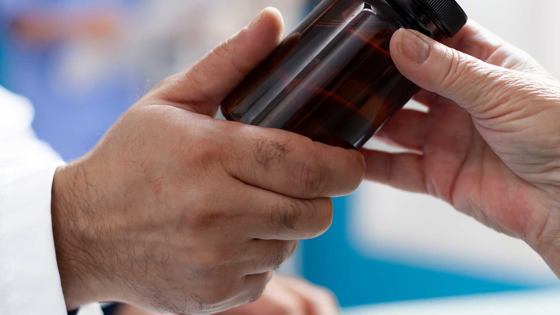 Médico entregando un frasco