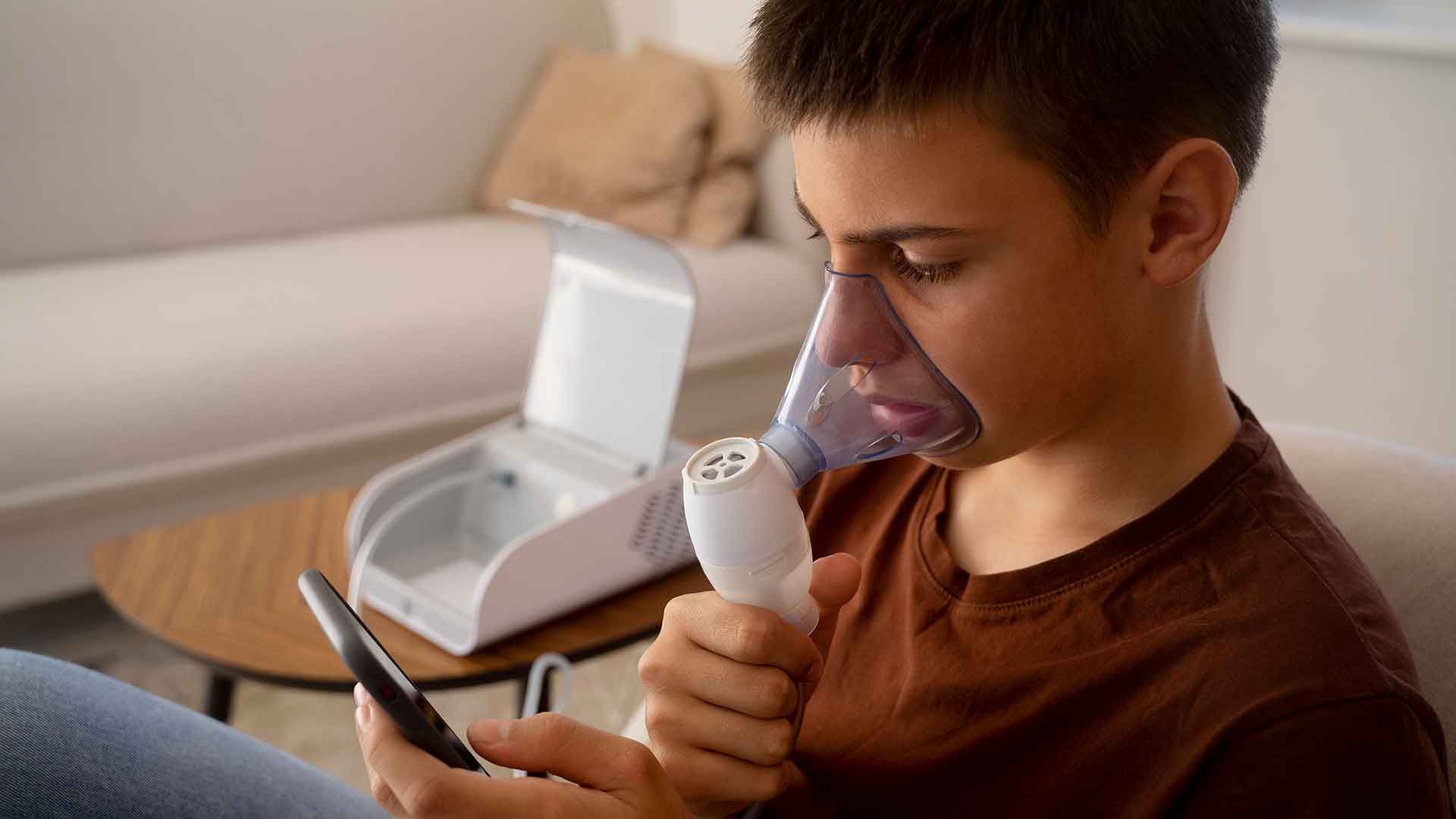 Chico inhalando un medicamento