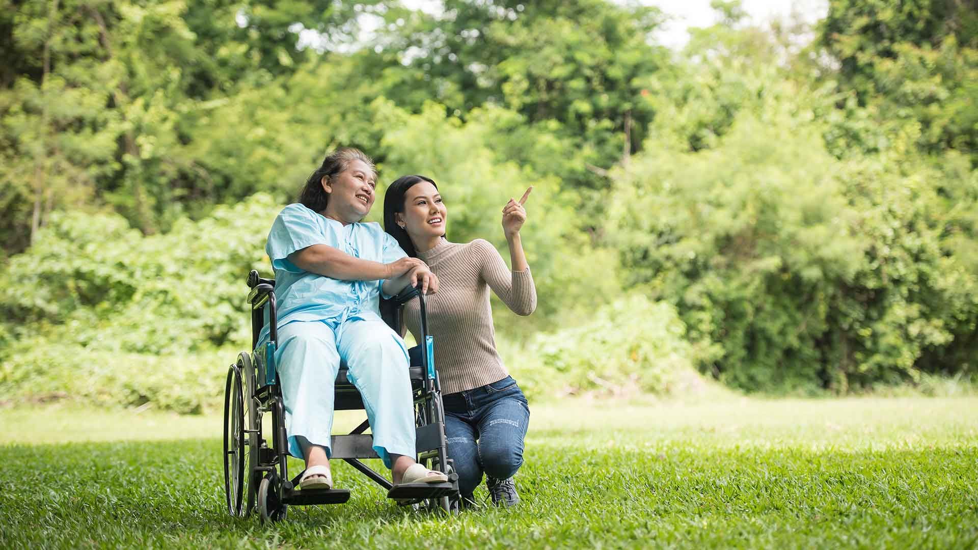 Persona en silla de ruedas con cuidadora