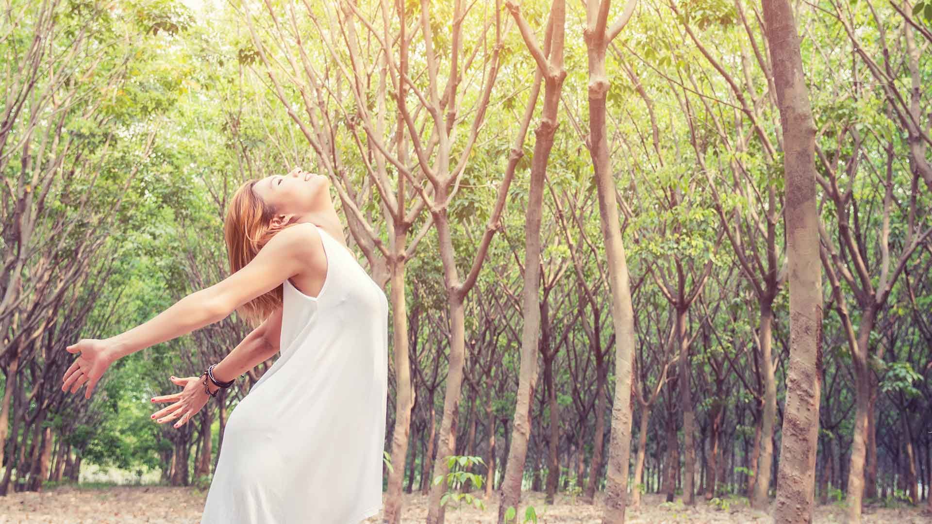 Mujer respirando en el bosque
